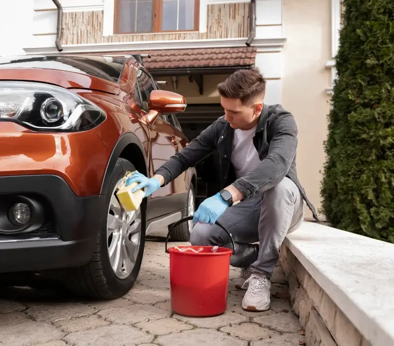 Lavage auto à domicile Pouzols : professionnel intervenant sur un véhicule